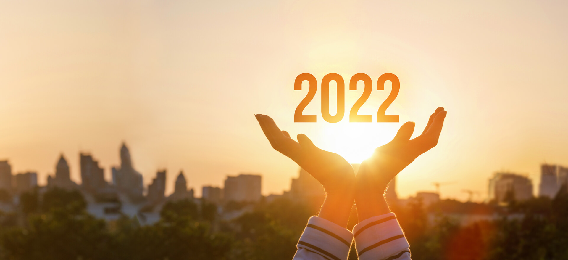 Geste offene Hände mit 2022 darüber vor einem Sonnenuntergang