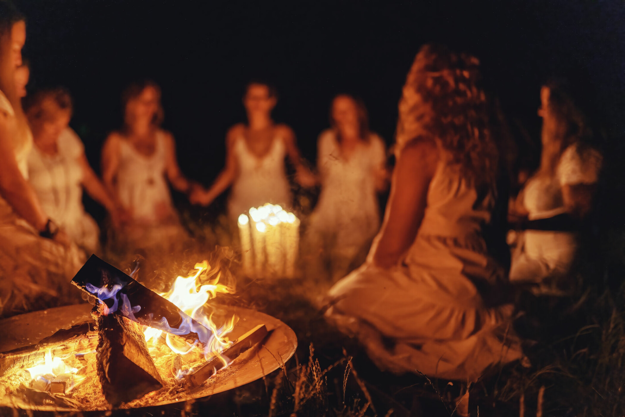 Frauen sitzen am Feuer